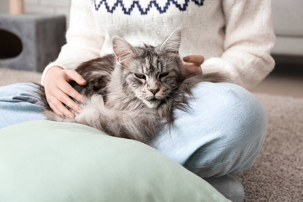 Woman with Maine Coon cat sitting on floor at home - Photo, Image