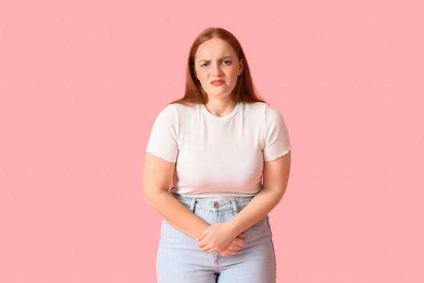 Young woman having menstrual cramps on pink background - Photo, Image