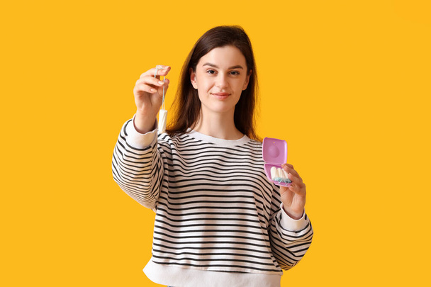 Young woman with box of tampons on orange background - Photo, Image