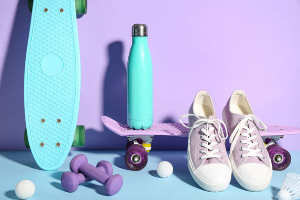 Σύνθεση με αθλητικό εξοπλισμό, παπούτσια και μπουκάλι νερό σε φόντο χρώματος - Φωτογραφία, εικόνα