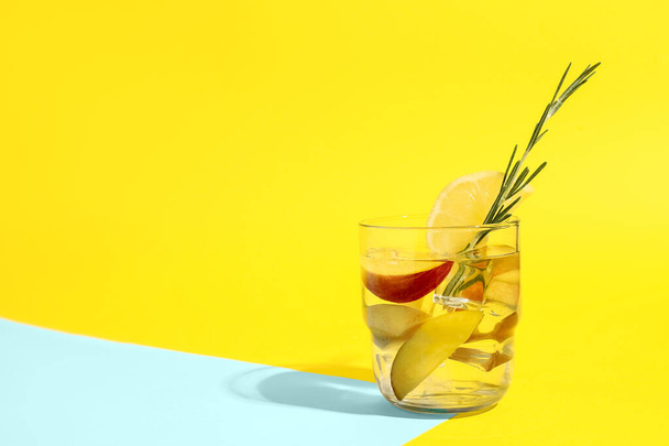Glass of fresh peach lemonade with rosemary on colorful background - Foto, immagini
