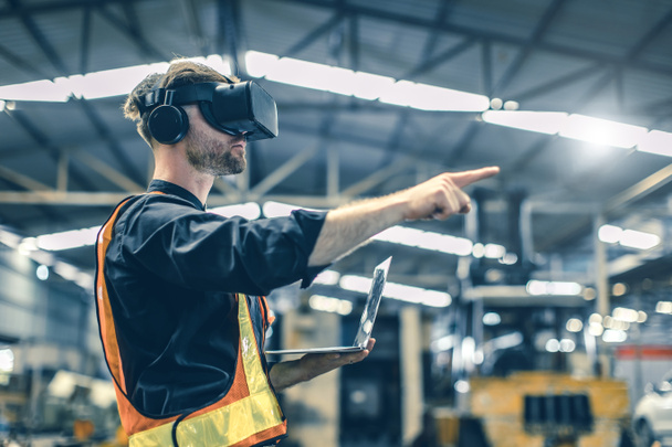Μηχανικός αρσενικός που χρησιμοποιεί τεχνολογία εικονικής πραγματικότητας VR σε σύγχρονη αποθήκη εργοστάσιο νέας τεχνολογίας καινοτομίας - Φωτογραφία, εικόνα