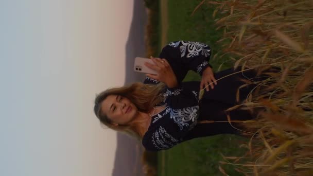 Vertical video pretty woman in national dress makes selfie - Footage, Video