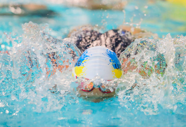 Połtawa, Ukraina - 23 czerwca 2023: Pływak pływa w basenie podczas młodzieżowych mistrzostw Ukrainy w Aquaarenie (kompleks sportowy) - Zdjęcie, obraz