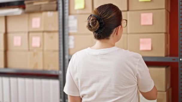Młoda piękna latynoska kobieta e-commerce pracownik biznesu biorąc pakiet od siebie w biurze - Materiał filmowy, wideo