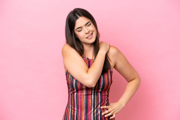 Young Brazilian woman isolated on pink background suffering from pain in shoulder for having made an effort - Foto, afbeelding