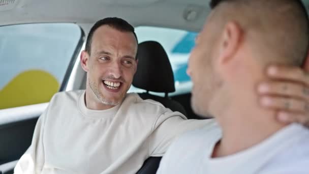Dos hombres pareja conduciendo coche tocando cabeza en la calle - Imágenes, Vídeo