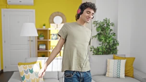 Joven hispano escuchando música bailando en casa - Imágenes, Vídeo