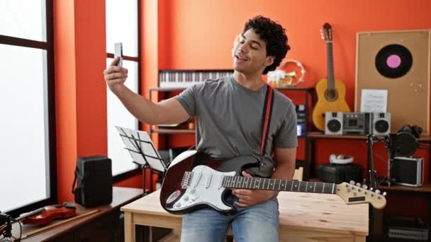Giovane musicista latino con videochiamata sorridente allo studio di musica - Filmati, video
