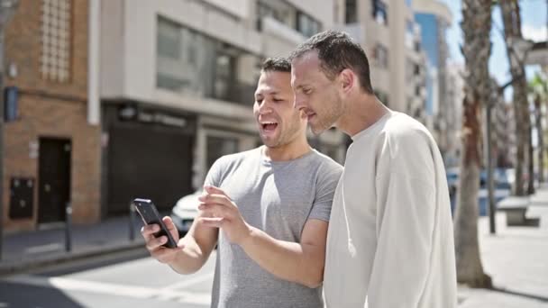 Δύο άνδρες ζευγάρι χαμογελώντας σίγουροι ότι έχουν βιντεοκλήση στο δρόμο - Πλάνα, βίντεο