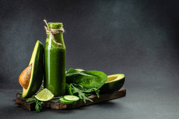 Batido verde en frasco de vidrio con verduras verdes orgánicas frescas sobre un fondo oscuro. banner, menú, lugar de la receta para el texto. - Foto, imagen