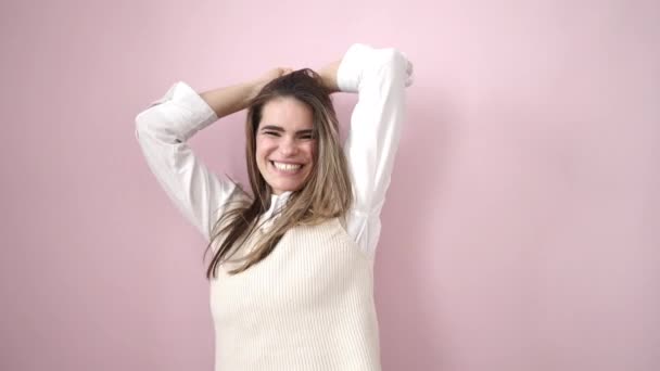 jong mooi latino vrouw glimlachen en dansen over geïsoleerde roze achtergrond - Video