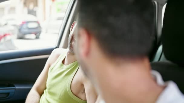 Deux hommes couple assis en voiture souriant à la rue - Séquence, vidéo
