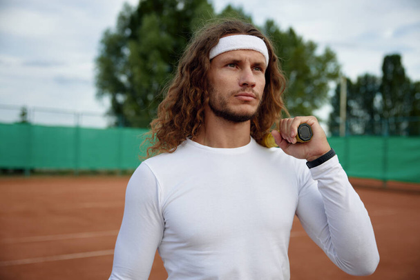 Portré férfi teniszező visel divatos ruhát készen áll a reggeli edzés a szabadtéri pályán - Fotó, kép