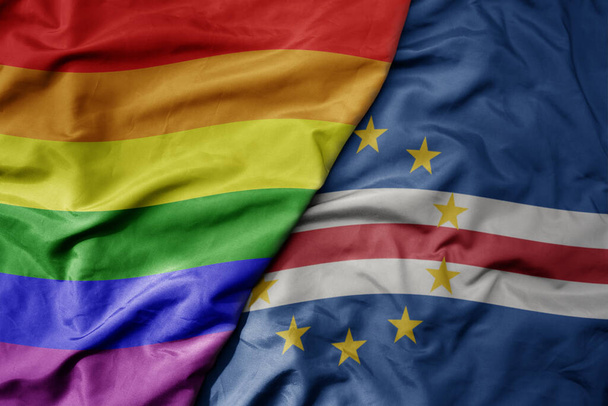 grande acenando bandeira colorida nacional realista de cabo verde e arco-íris bandeira orgulho gay. macro - Foto, Imagem