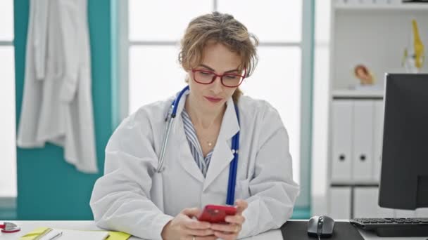 Jonge vrouw arts met behulp van smartphone werken in de kliniek - Video
