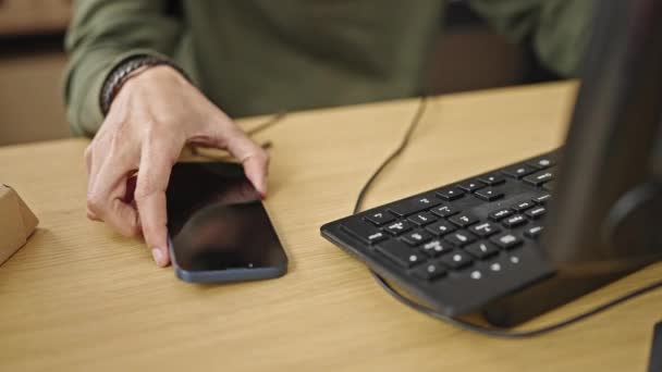 Joven hombre hispano comercio electrónico trabajador de negocios utilizando la computadora y el teléfono inteligente en la oficina - Imágenes, Vídeo
