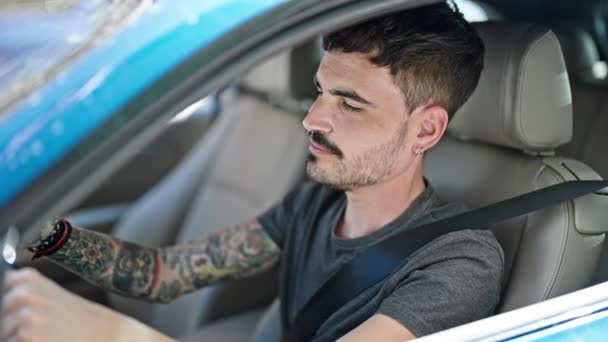 Young hispanic man sitting on car dancing at street - Footage, Video