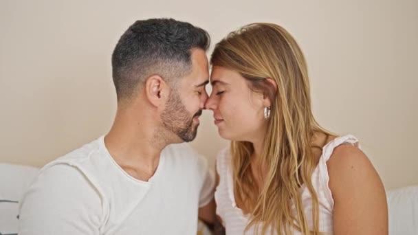 man en vrouw paar zitten op bed knuffelen elkaar zoenen in slaapkamer - Video