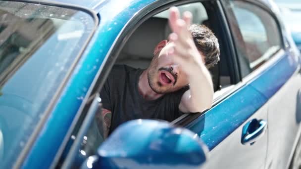 Joven hispano estresado conduciendo coche gritando en la calle - Metraje, vídeo