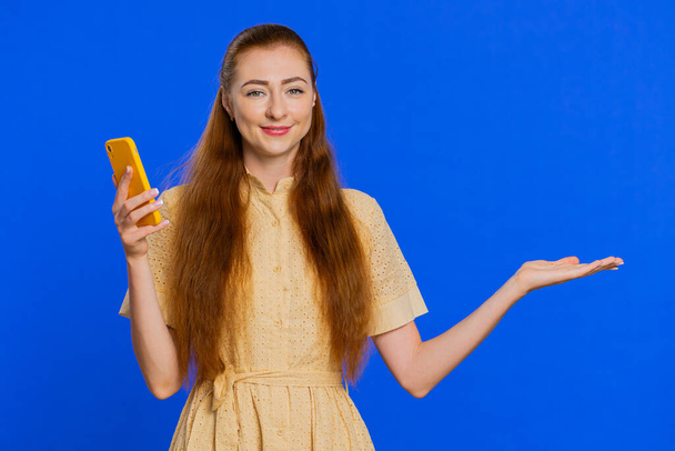 Fiatal felnőtt vörös hajú nő lány használ okostelefon gépelés új hozzászólás az interneten, böngészés, keresés, függőség a szociális hálózatok, mutasd hüvelykujj fel, mint, pozitív visszajelzés ajánlja wifi sejt kapcsolat 5G - Fotó, kép