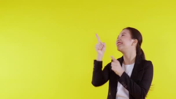 Portrait young asian business woman pointing and presenting isolated on yellow background, advertising and marketing, woman surprise and excited, businesswoman confident showing with expression. - Footage, Video