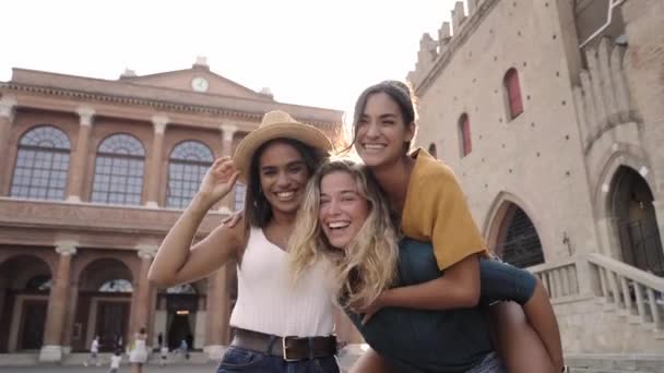 Tres amigas felices divirtiéndose al aire libre en las vacaciones de verano en la ciudad. Retrato de una mujer sonriente abrazándose mirando a la cámara juntos. Foto de alta calidad - Metraje, vídeo