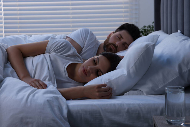 Lovely couple sleeping together in bed at night - Photo, image