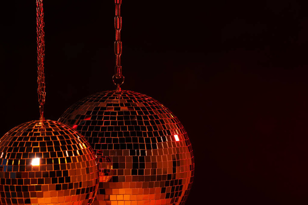 Shiny bright disco balls under red light, space for text - Photo, image