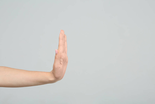 Woman showing stop gesture on light grey background, closeup. Space for text - Fotografie, Obrázek