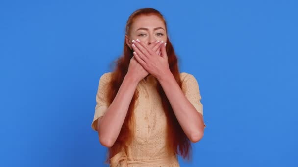 I will not say anything. Frightened woman closing mouth with hands, looking intimidated scared at camera, gestures no, refusing to tell terrible secret, unbelievable truth. Girl on blue background - Footage, Video