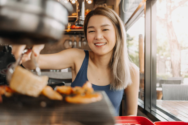 Happy asian woman eating korean grilled buffet in the restaurant. - Photo, image