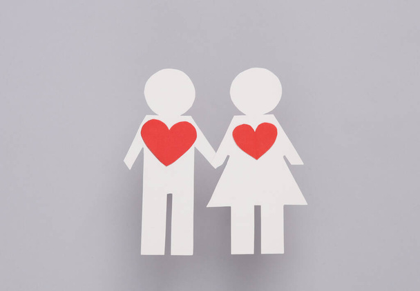 Love concept. Paper cut couple in love with a hearts on a gray background - Photo, Image