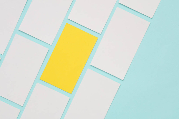 Κίτρινες και λευκές επαγγελματικές κάρτες σε μπλε φόντο. Εταιρική ταυτότητα, έννοια της μοναδικότητας - Φωτογραφία, εικόνα