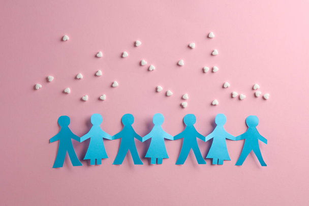 Перерезанная бумага цепь людей и таблетки в форме сердца на розовом фоне - Фото, изображение