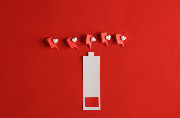 Papel de corte de batería baja con Social media le gusta sobre fondo rojo. Diseño mínimo creativo - Foto, imagen