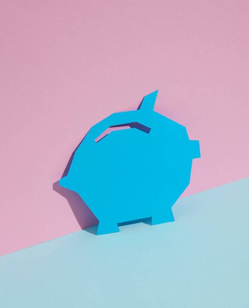 Paper-cut Piggy bank on blue-pink pastel background. Creative layout - Photo, Image