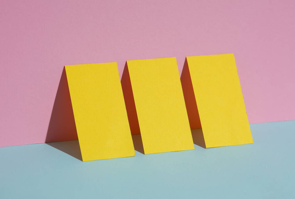 Yellow blank business cards on a blue-pink pastel background. Creative minimal layout. Corporate identity - Photo, Image