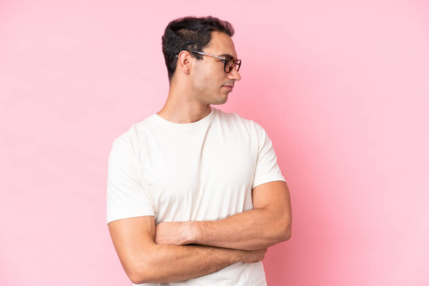 Young caucasian man isolated on pink background keeping the arms crossed - Photo, Image