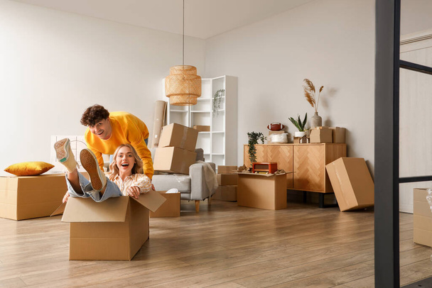 Young couple having fun in room on moving day - Foto, Imagem