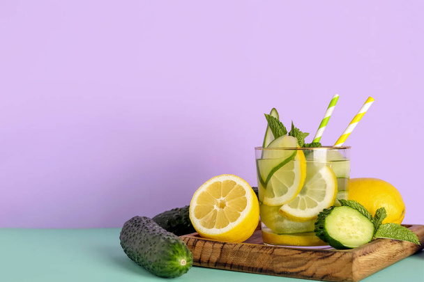 Verre de limonade avec concombre et menthe sur fond coloré - Photo, image