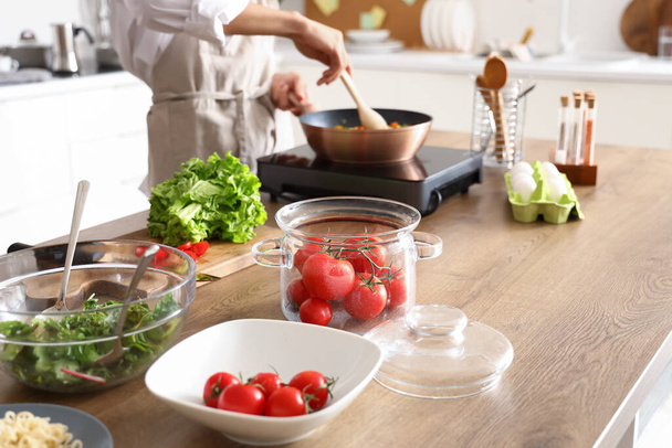 Fresh tomatoes on table in kitchen, closeup - Zdjęcie, obraz