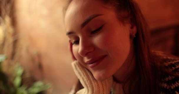 Portret van een mooi, jong meisje zittend aan een cafe tafel op een romantische date. - Video