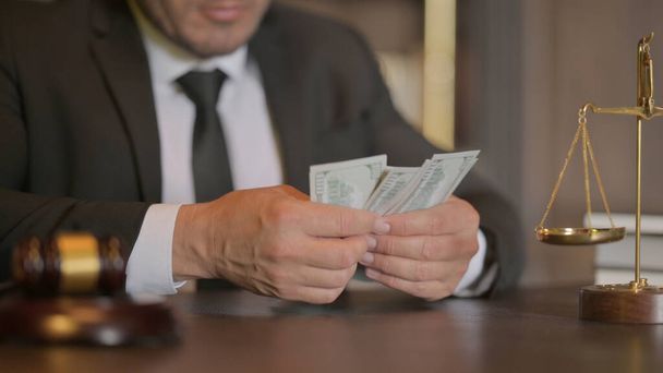 Gelukkige mannelijke advocaat telt geld in het kantoor - Foto, afbeelding