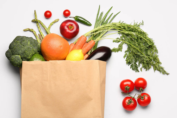 Bolsa de papel con verduras y frutas sobre fondo gris - Foto, Imagen