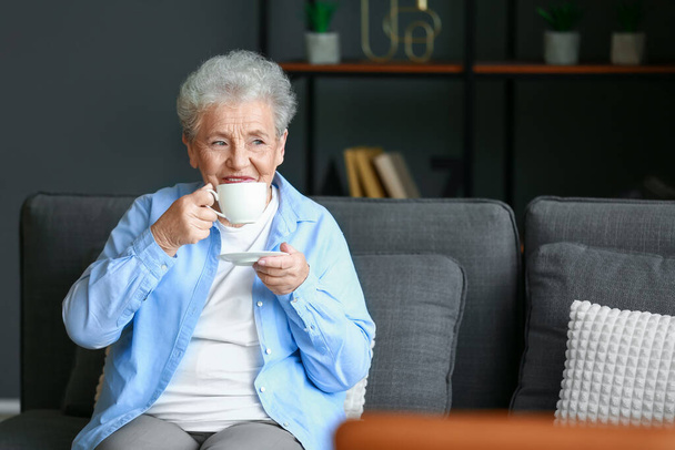 Senior woman drinking coffee at home - Фото, изображение