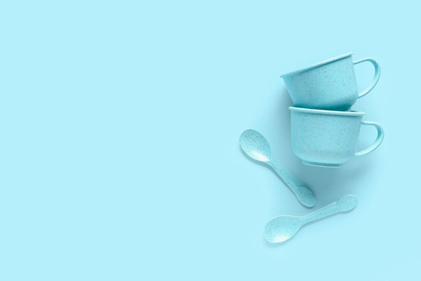 Cups with spoons for baby on blue background - Photo, image