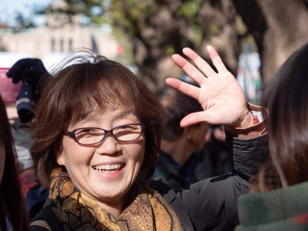 カメラに向かって手を振る幸せな日本人女性 - 写真・画像