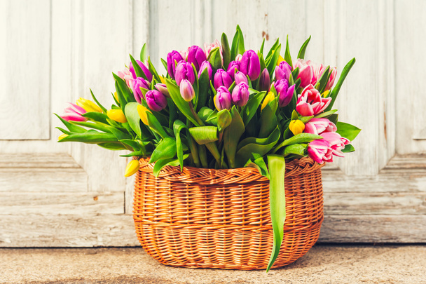 Cesta grande cheia de muitas tulipas coloridas frescas, ao ar livre
 - Foto, Imagem