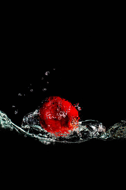 bright juicy fruits with splashes fly into the aquarium on a black background - Photo, Image